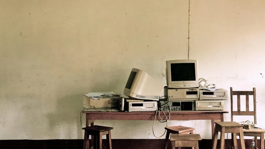 Person looking frustrated at an old laptop with expiration concept, representing technology obsolescence