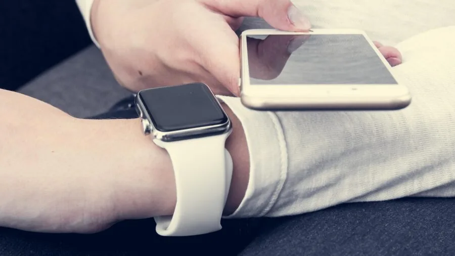 Person making contactless payment with smartwatch at checkout counter