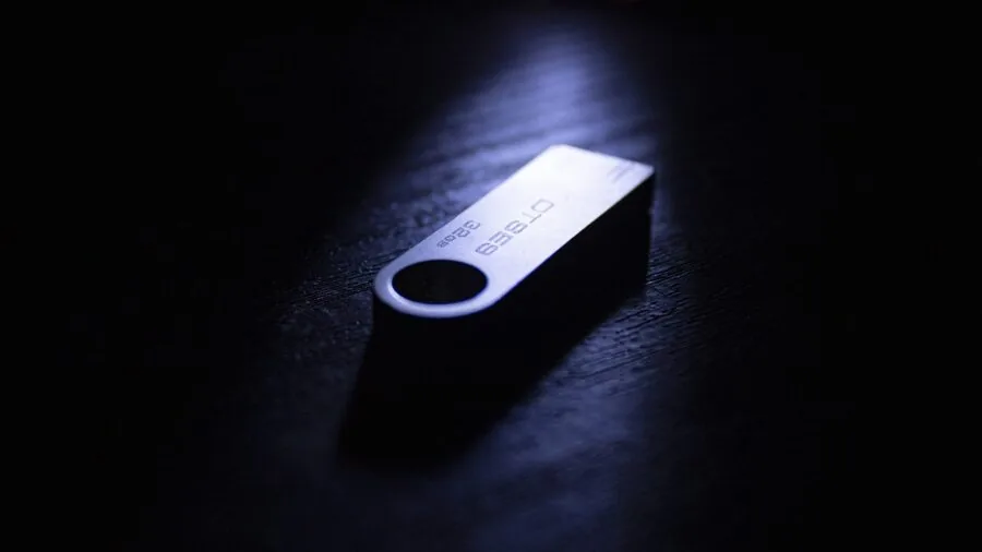 Person managing digital files and backup storage on computer workspace