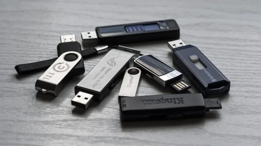 Person managing storage devices and digital files on desk