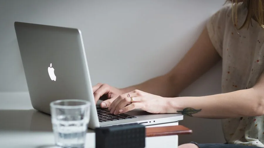 Person multitasking on laptop with multiple windows and applications open simultaneously