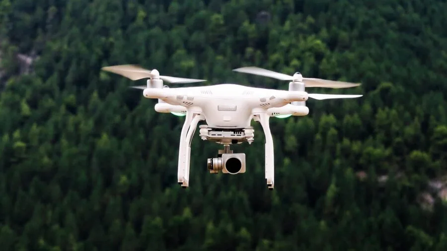 Person operating drone in open field with safety awareness and outdoor landscape