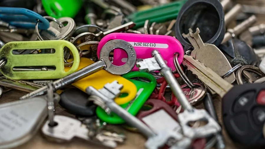 Person organizing and managing their keys on a keyring in a real-life setting
