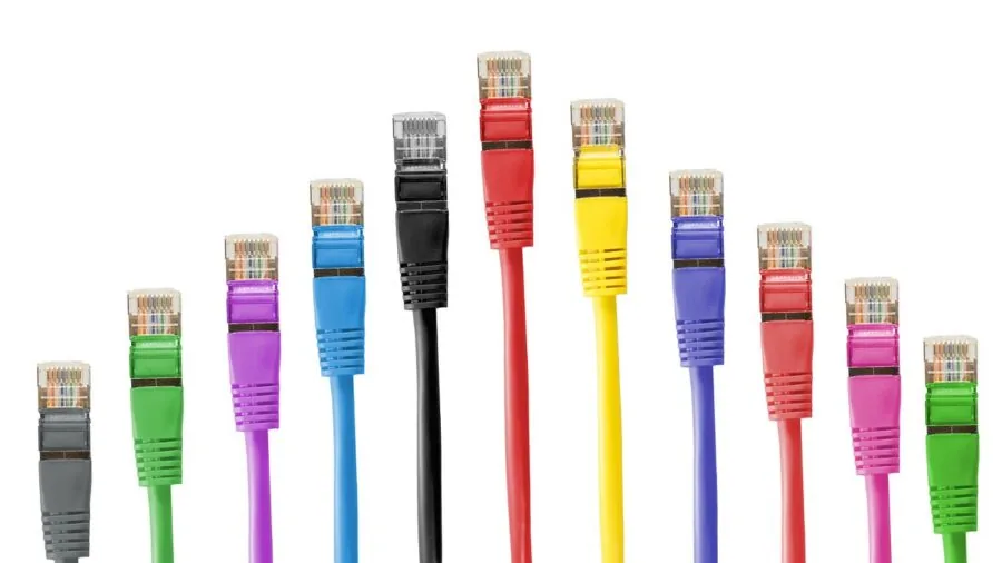 Person organizing network cables and equipment for gaming setup, demonstrating ethernet connectivity solutions