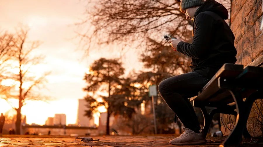 person playing mobile game outdoors