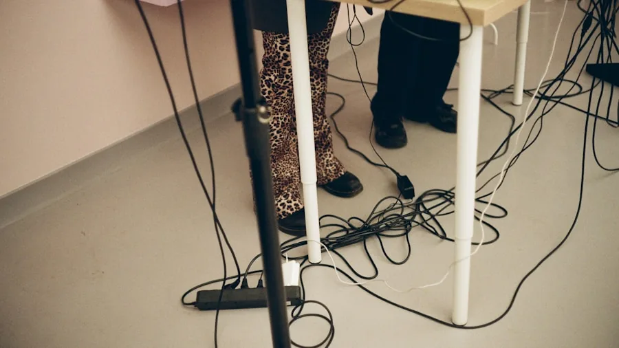 Person plugging cables into back of computer monitor at organized desk workspace