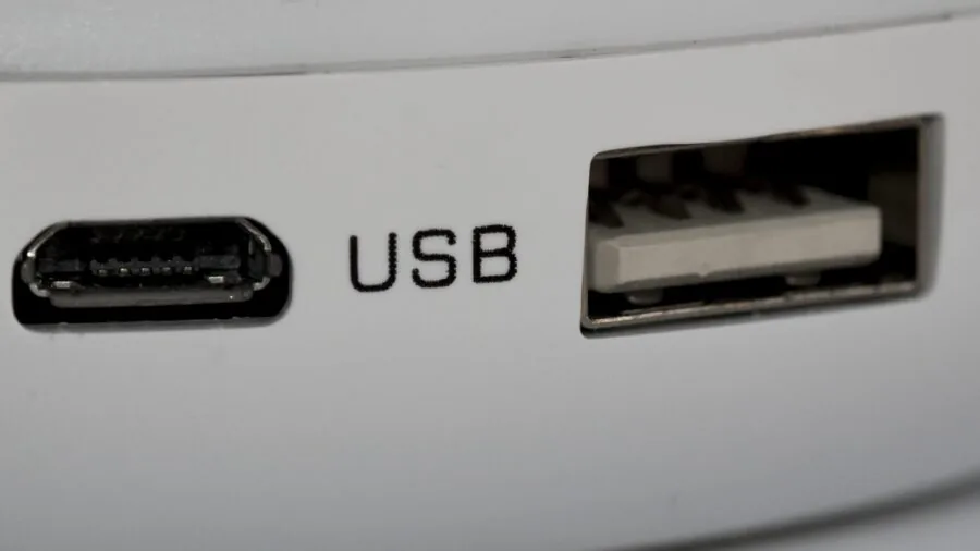 Person plugging USB-C cable into desktop computer on workspace desk