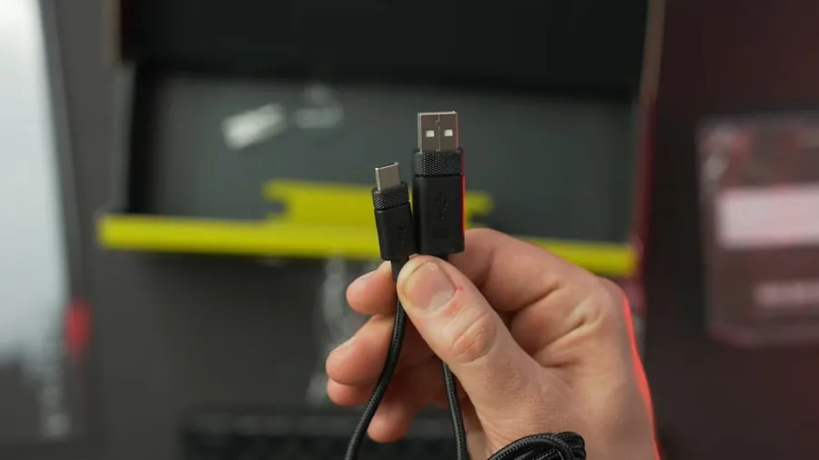 Person plugging USB-C cable into laptop for high-speed data transfer and streaming setup