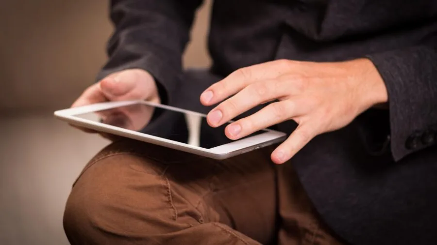 Person plugging USB cable into drawing tablet connected to laptop for creative work setup