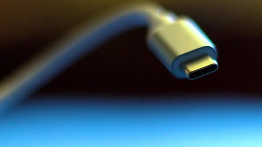 Person plugging USB cable into laptop for data transfer