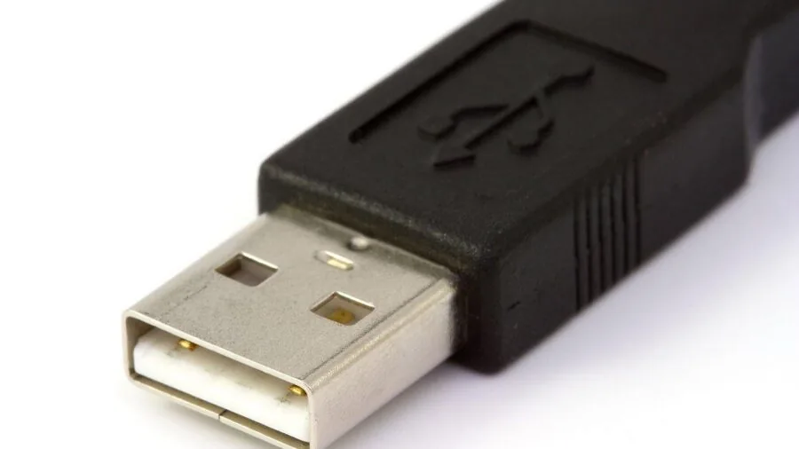 Person plugging USB cable into laptop port for data transfer and device connectivity