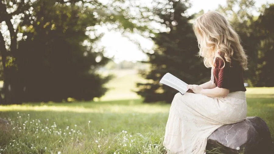 Person relaxing while reading on a digital device in a comfortable home setting