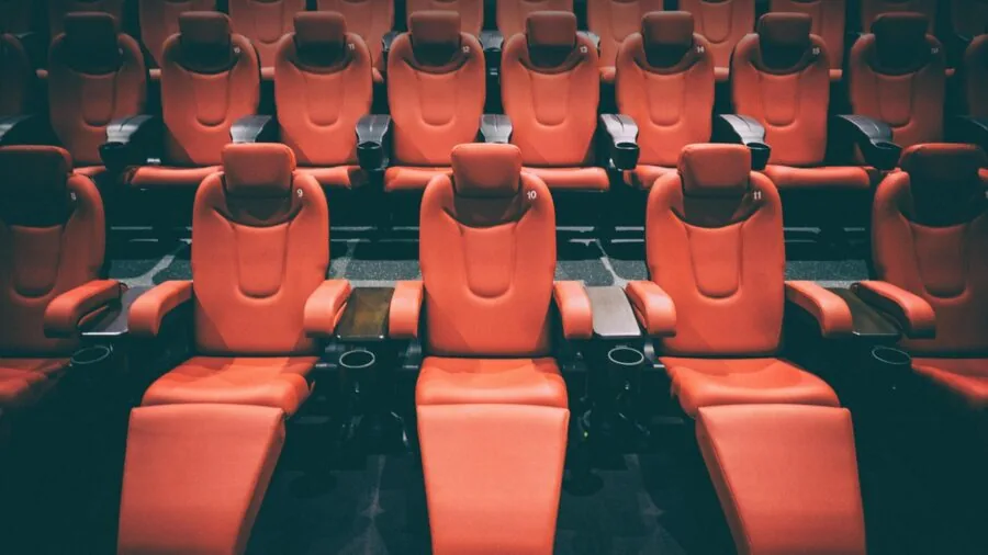Person relaxing while watching a movie on a portable device in a comfortable indoor setting