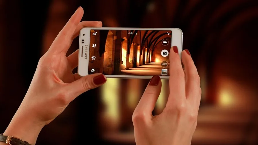 Person reviewing and sharing photos on smartphone in natural setting