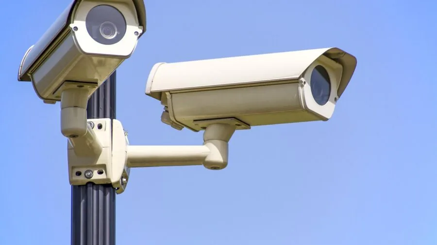 Person reviewing security camera footage on screen at night, focused on surveillance monitoring