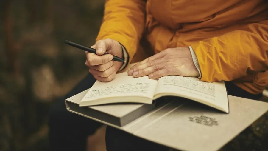 Person reviewing technical specifications and comparison documents while taking notes at a desk