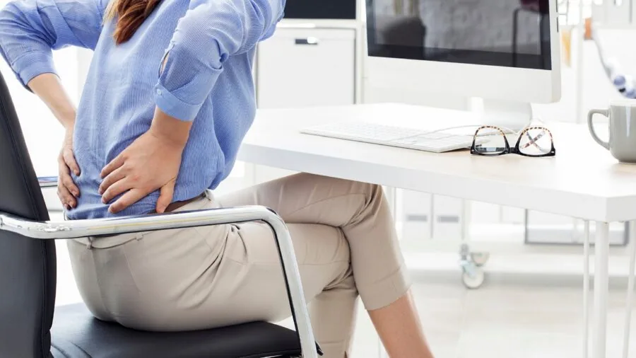 Person sitting at gaming desk with proper monitor height and ergonomic posture during gameplay session