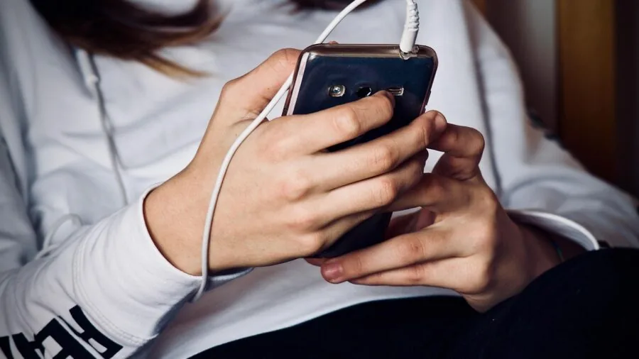 Person sitting on couch concentrating while listening to sound from speakers