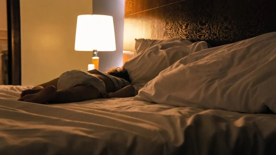 Person sleeping deeply in bed at night, demonstrating different sleep stages and rest quality