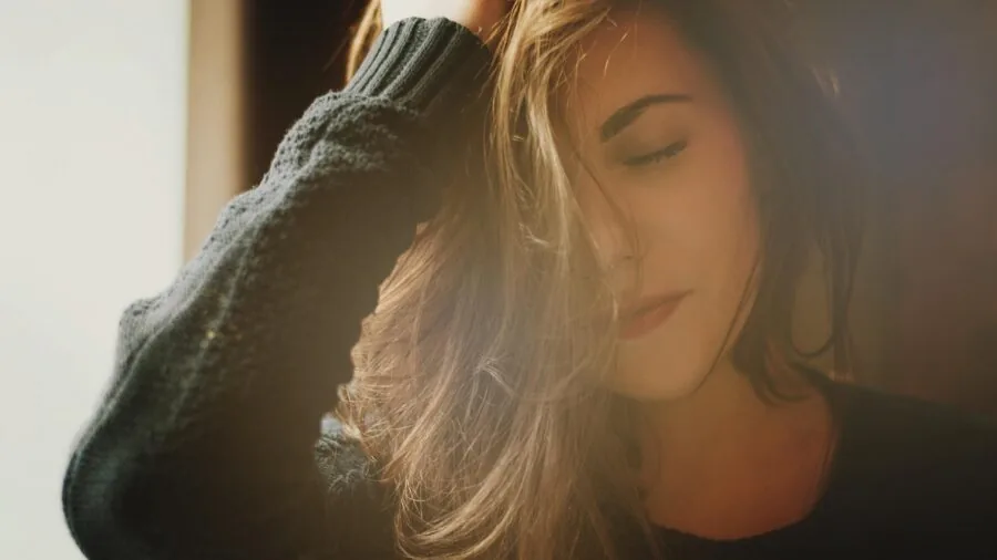 Person sleeping soundly in bed during early morning light, representing healthy sleep recovery and wellness tracking.