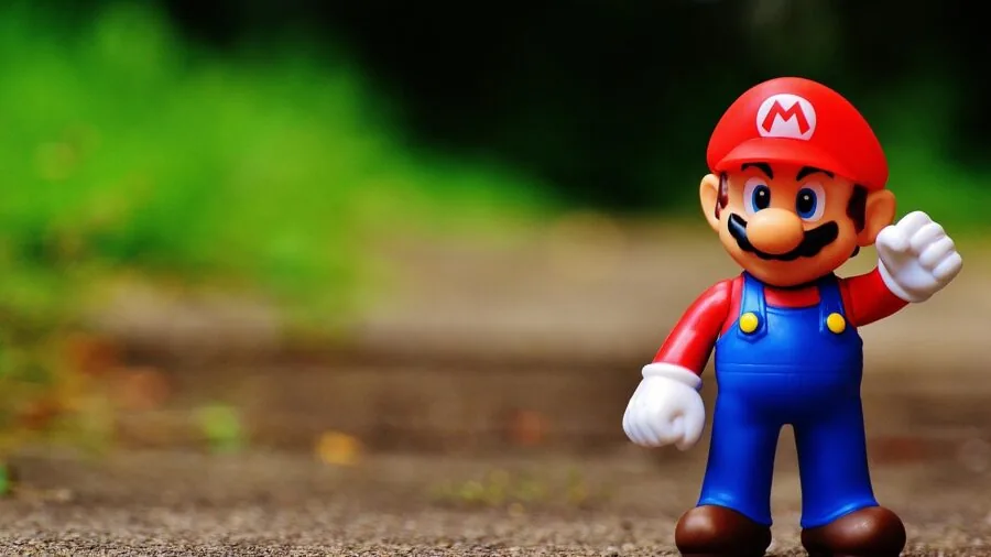 Person thoughtfully selecting a gaming console, examining options for gameplay preferences