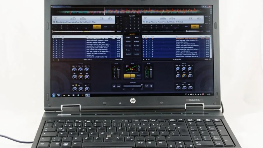 Person using computer with audio editing software interface visible on screen for music production