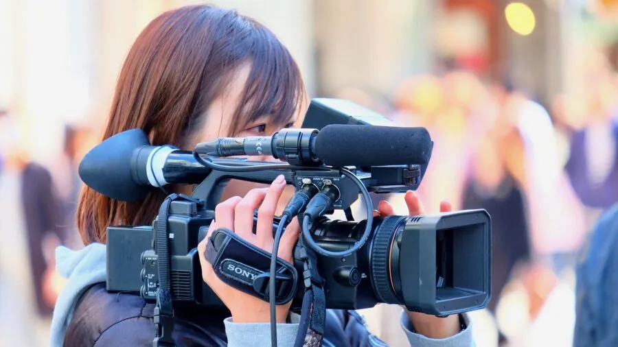 Person using handheld device to record video outdoors in natural lighting