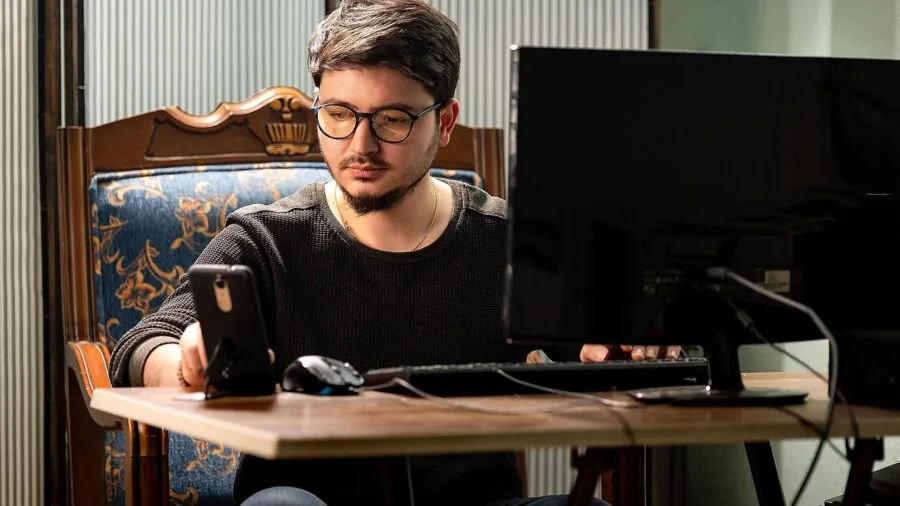 Person using laptop at desk in modern workspace, representing cross-platform device compatibility