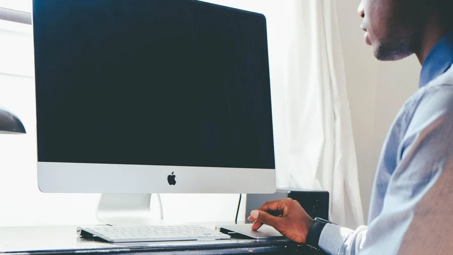 Person using laptop at desk while working productively on computer tasks