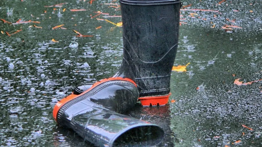 Person using outdoor gear in heavy rain and wet conditions to test water resistance and durability