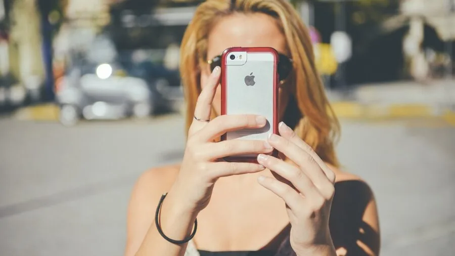Person using smartphone in wet environment demonstrating water resistance and durability during outdoor activity