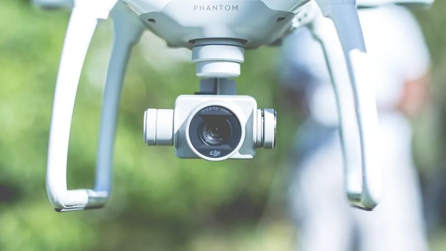 Person using smartphone to control outdoor camera equipment during adventure activity