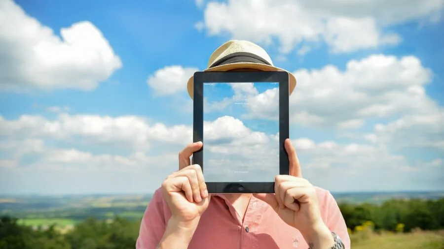 Person using tablet device while sitting outdoors in natural daylight