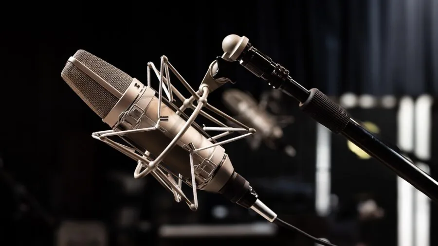 Person using wireless microphone during live recording session in professional studio environment