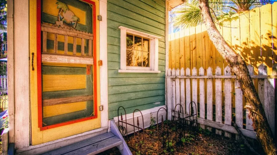 Person walking through front door entering home, representing smart home security and convenience