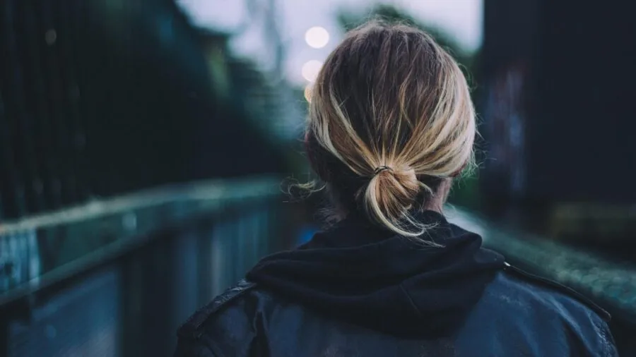 Person wearing earbuds on busy public transit commute with ambient background noise
