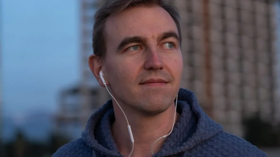 Person wearing earbuds on public transit, focused and undisturbed by surrounding noise