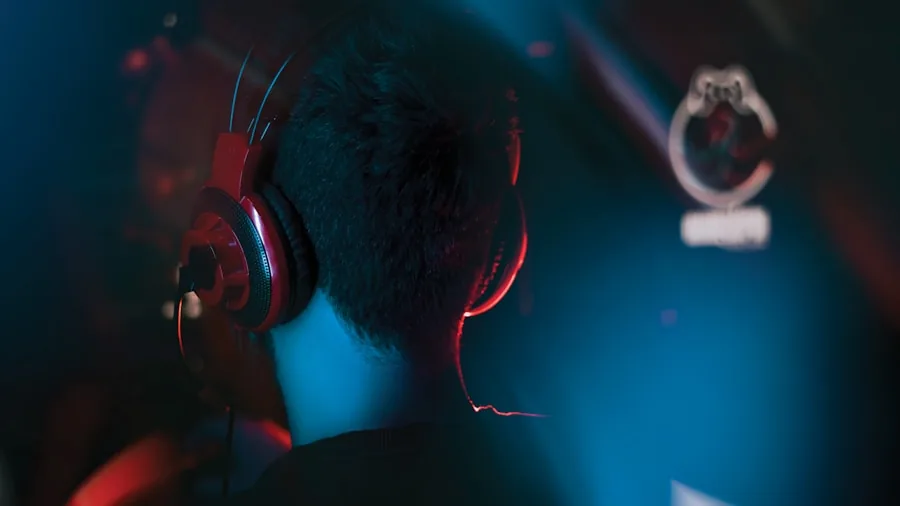 Person wearing gaming headphones focused on audio experience during gameplay session