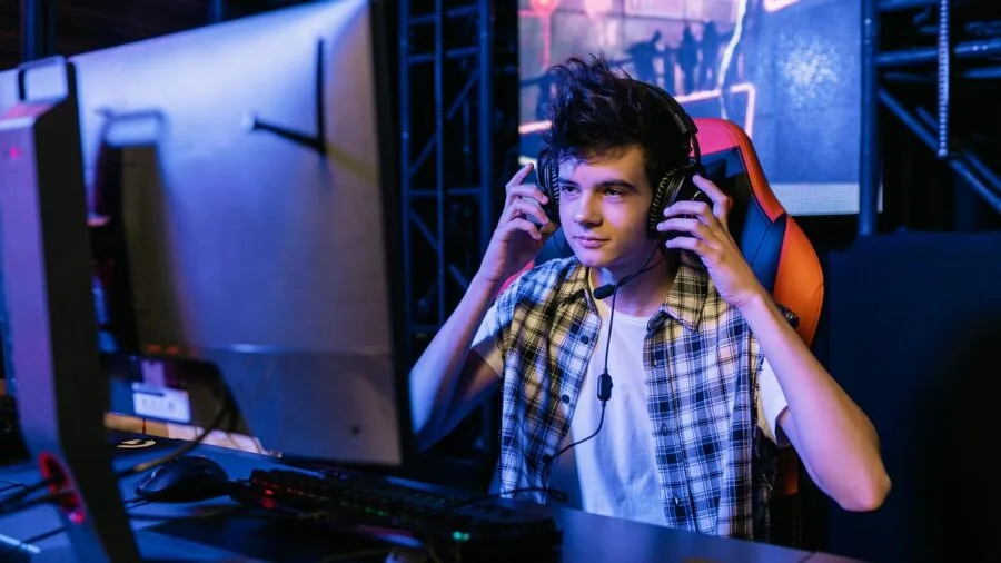 Person wearing gaming headset speaking into microphone during online multiplayer gaming session
