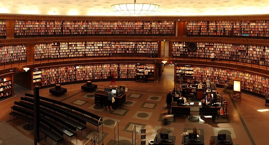 Person wearing headphones in a peaceful library environment, demonstrating appropriate listening space