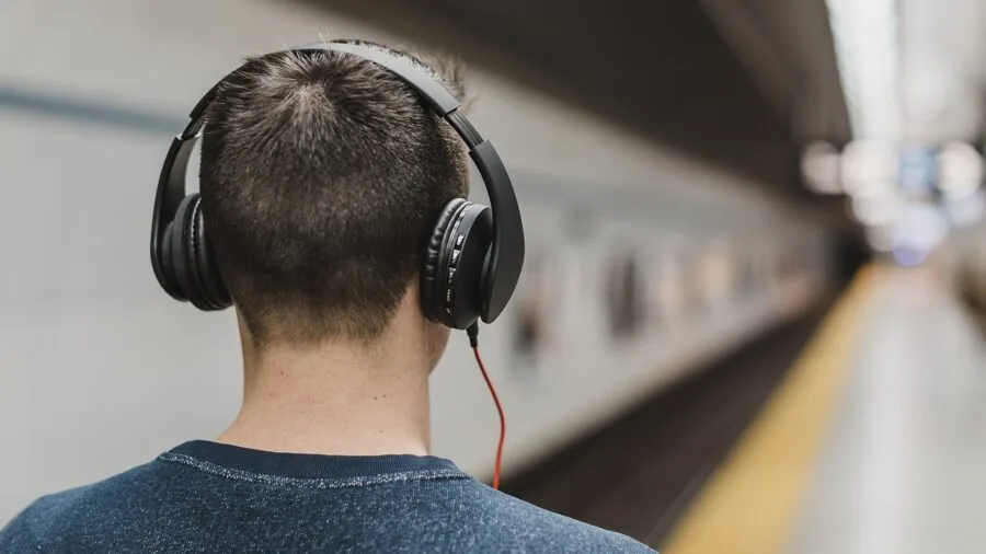 Person wearing headphones on public transportation, focused on sound quality and noise isolation in real environment