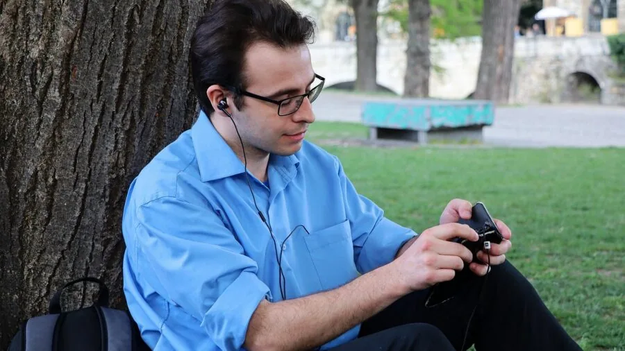 Person wearing smart glasses enjoying open-ear audio while walking outdoors in natural daylight
