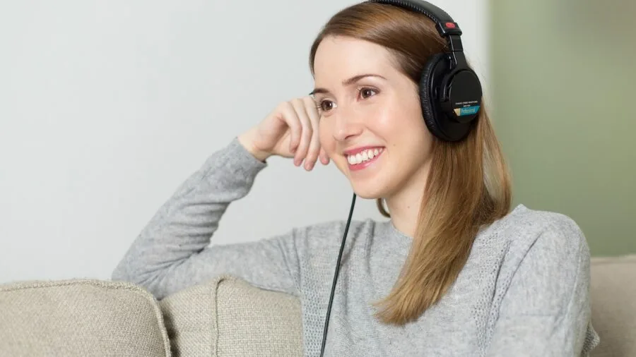 Person wearing wireless earbuds during everyday commute, checking battery life and connectivity