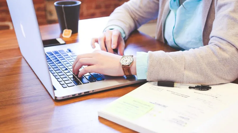 Person with small hands working at desk with wireless keyboard and mouse for productivity