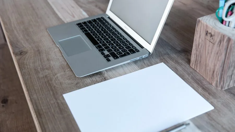 Person working at an expansive desk with multiple monitors in a modern home office environment