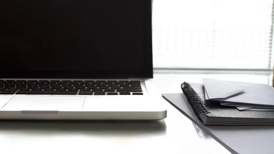 Person working at desk in home office environment with papers and computer setup
