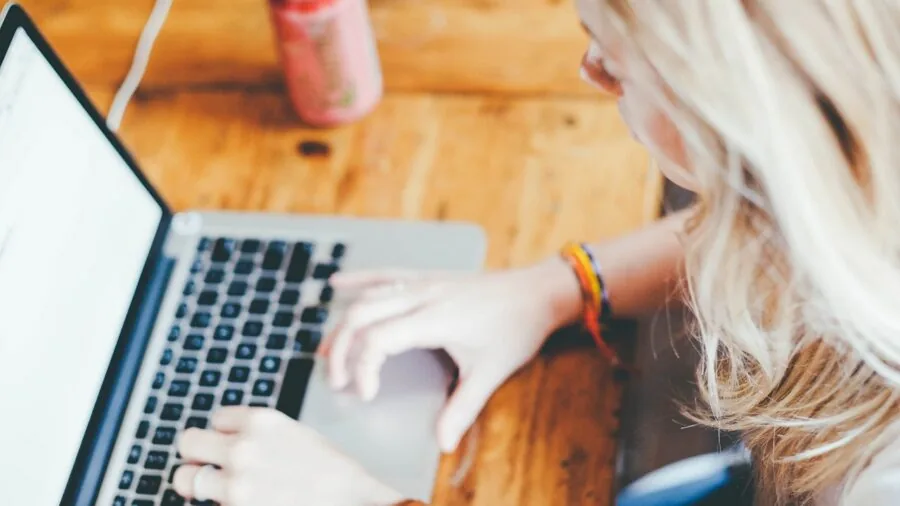 Person working at desk in quiet office environment, focused on computer task with peaceful expression