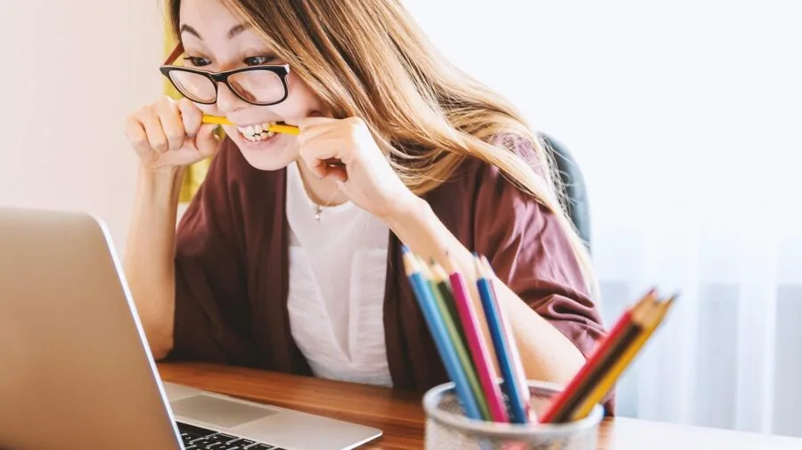 Person working at desk transferring digital files between devices with focused concentration