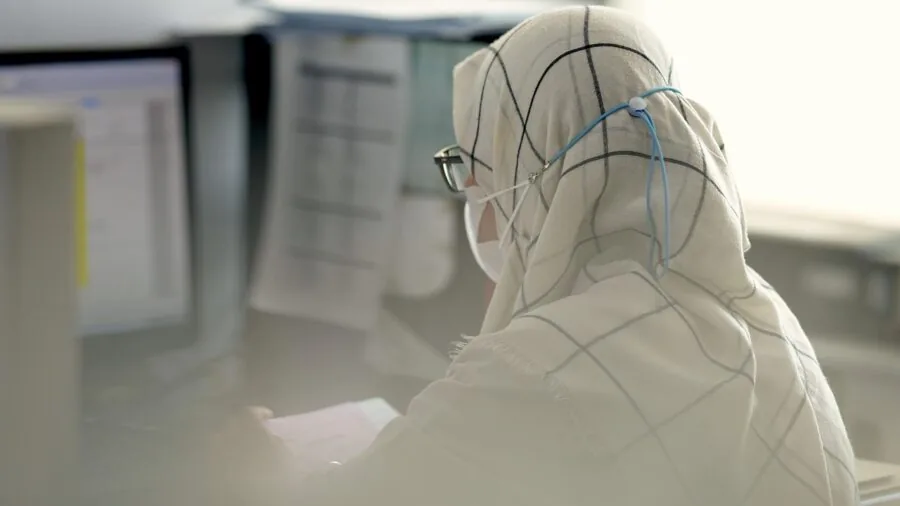 Person working at desk with multiple applications open, demonstrating multitasking productivity in home office