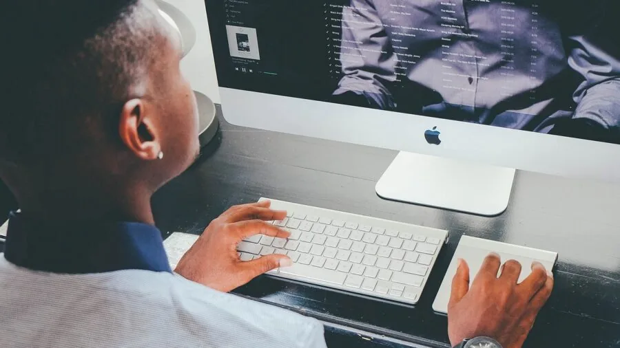 Person working at home desk with computer and internet equipment in background